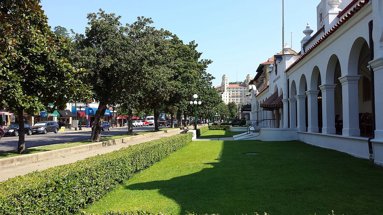 Bathhouse Row on Central Avenue in Hot Springs, with the row of Southern magnolias and the forested ridge behind